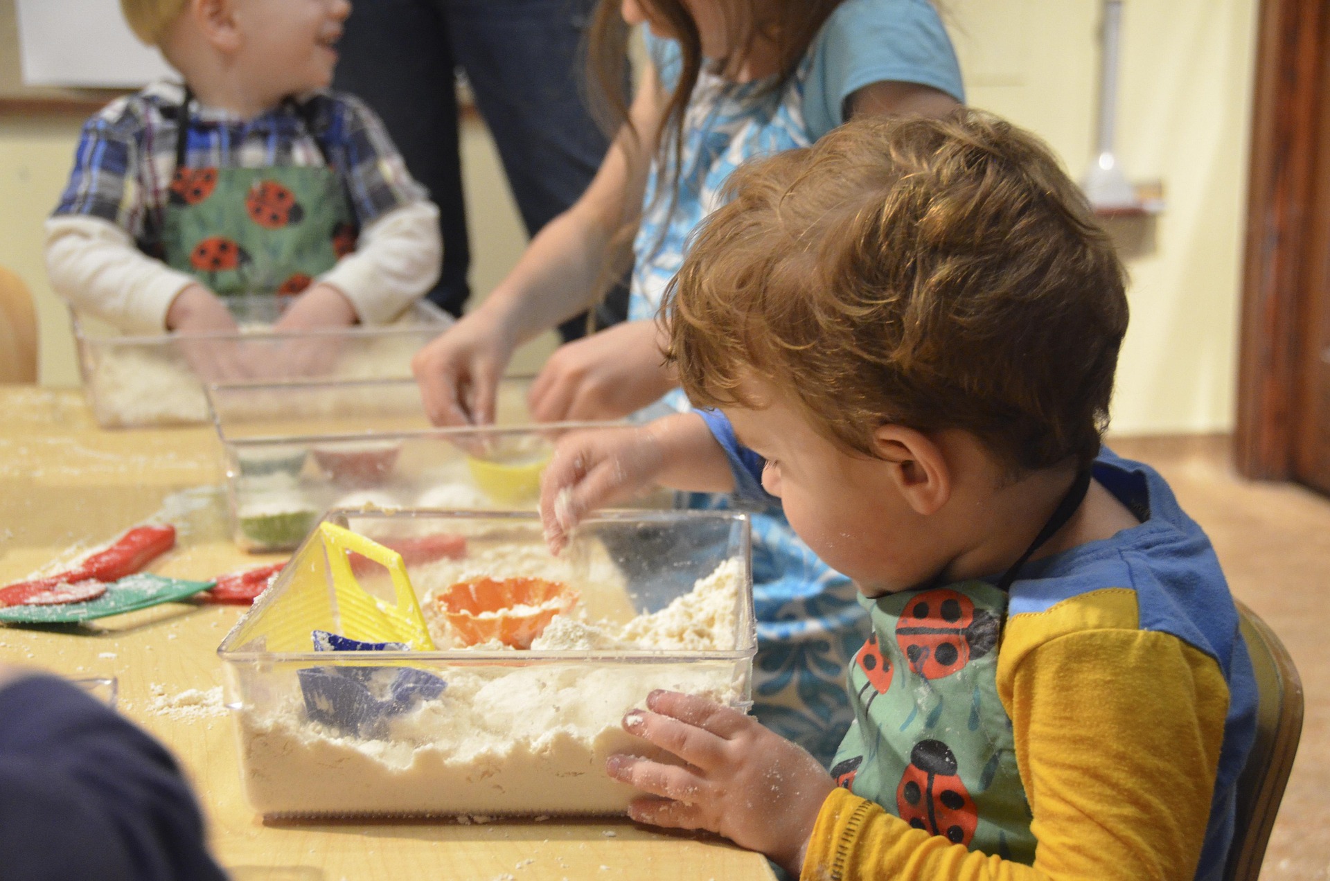 Child playing with a sand sensory bin.