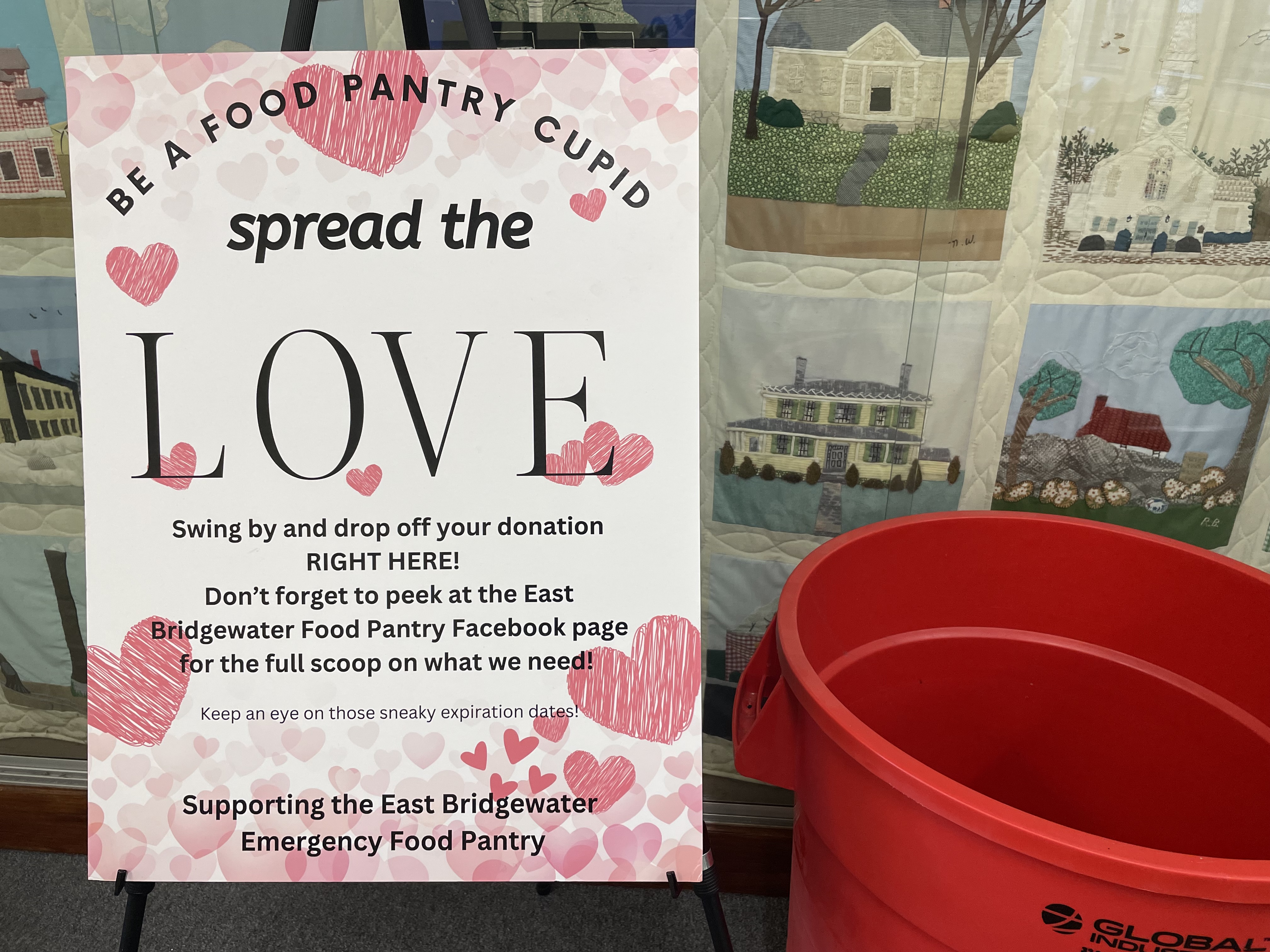 Pink Valentine's Food Pantry Sign and Red Donation Bucket in front of ramp quilt display