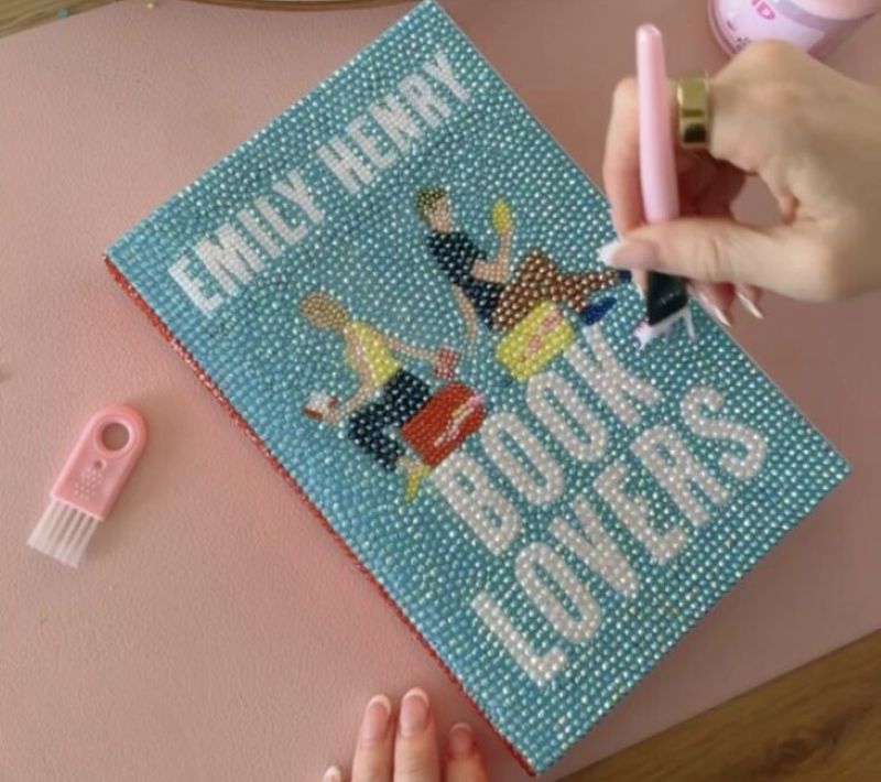 The title Book Lovers by Emily Henry being bedazzled with gems