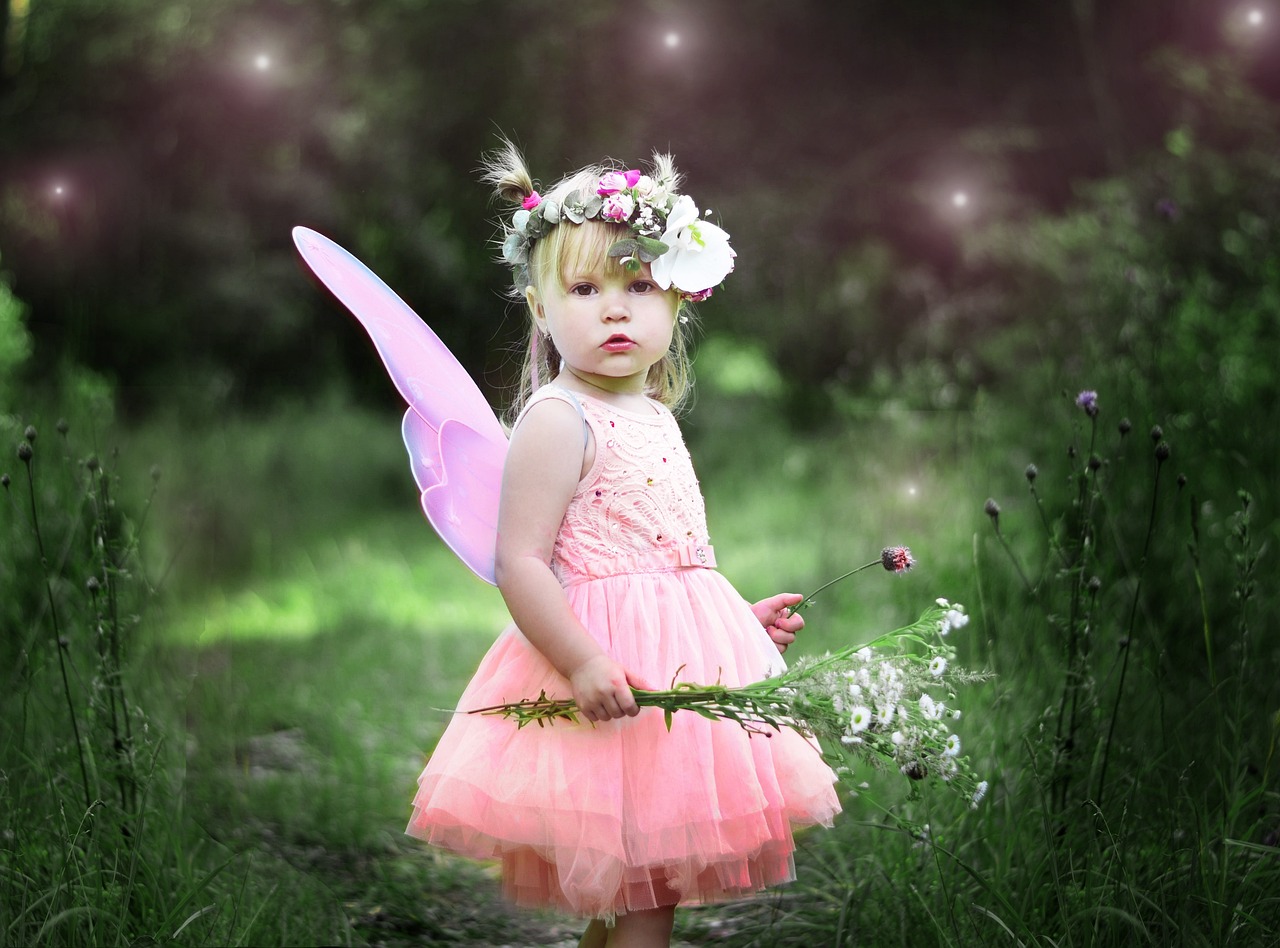 Little girl in pink tutu with wand and wings