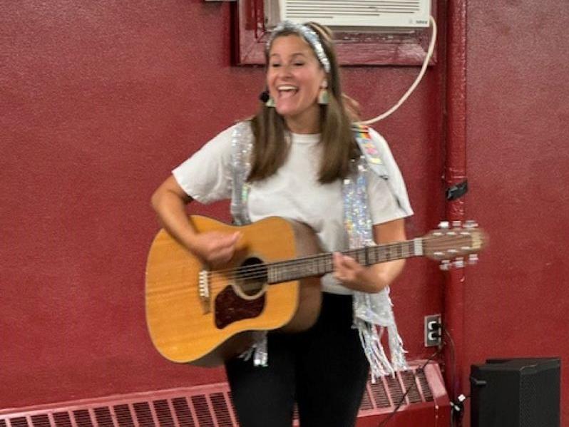 Miss Ari with a guitar singing a song.