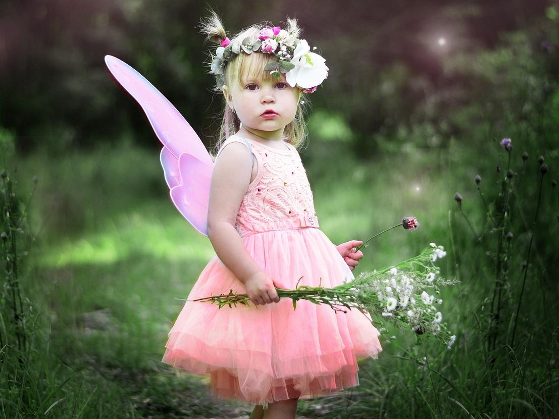 Little girl in pink tutu with wand and wings