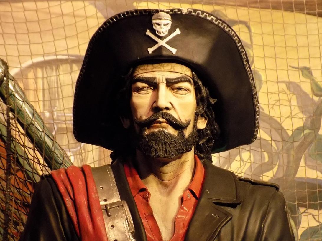 Pirate image standing in front of yellowed map