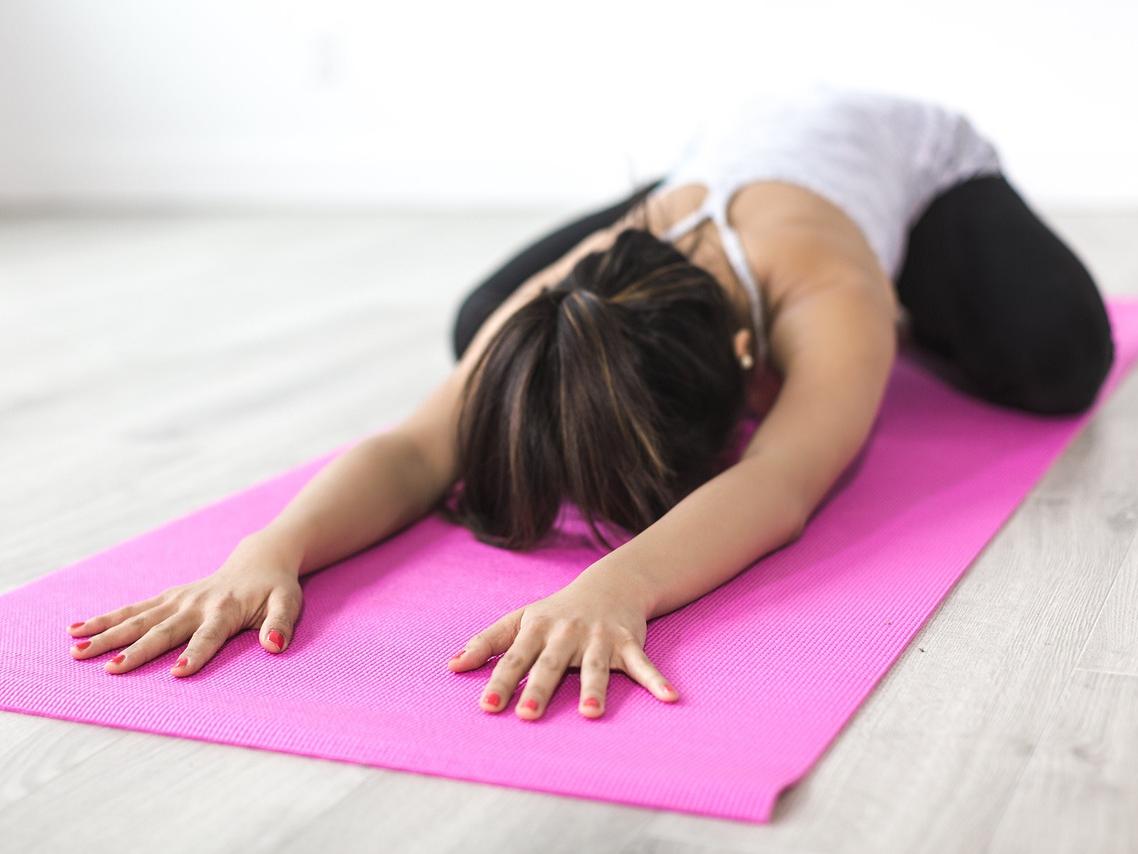 Woman stretching on yoga mat